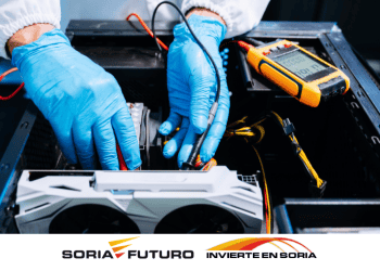 Técnico reparando equipo electrónico con herramientas en Soria, empresa innovadora.