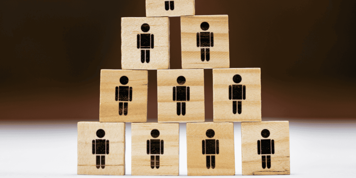 Personas con bloques de madera con iconos de figuras humanas para inversión en Soria.