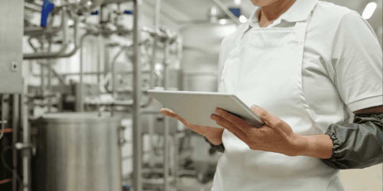 Persona en fábrica con tableta revisando procesos industriales en Soria.