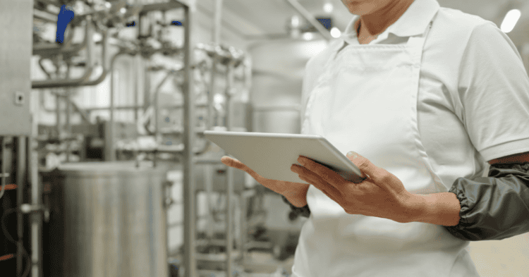 Persona en fábrica con tableta revisando procesos industriales en Soria.