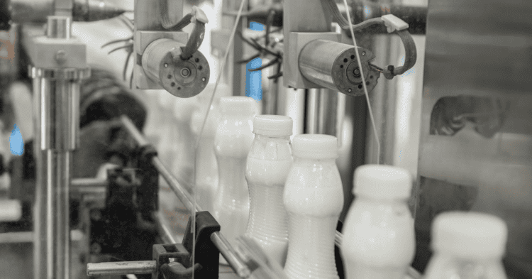 Máquina en línea produciendo botellas de leche en una fábrica en Soria.