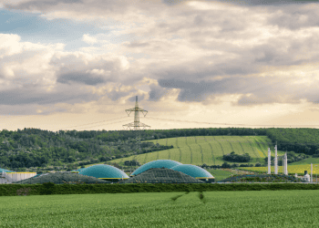 Planta de biometano en Soria con campos verdes y cielo nublado.