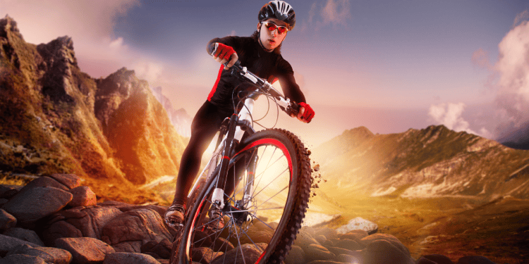 Mujer practicando ciclismo de montaña en Soria con paisaje montañoso al atardecer.