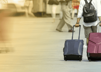 Persona con maletas en una estación de tren en Soria, turismo y viajes.