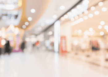 Interior de centro comercial en Soria con tiendas y visitantes.