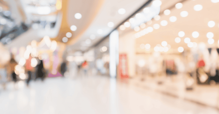 Interior de centro comercial en Soria con tiendas y visitantes.