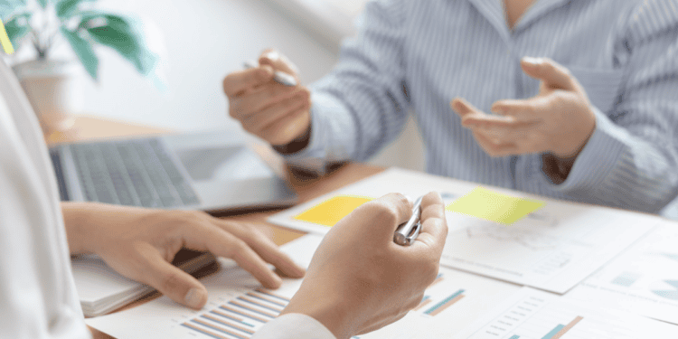 Reunión de negocios con análisis de datos y gráficos en oficina moderna.