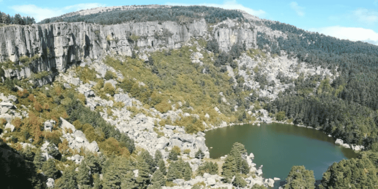 Lago rodeado de riscos y bosque en La Laguna Negra, paisaje de Castilla y León.